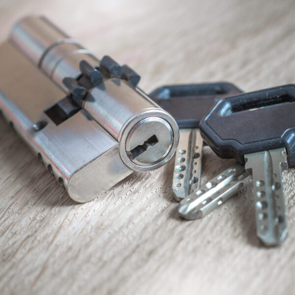 door lock with keys on wooden surface, close up